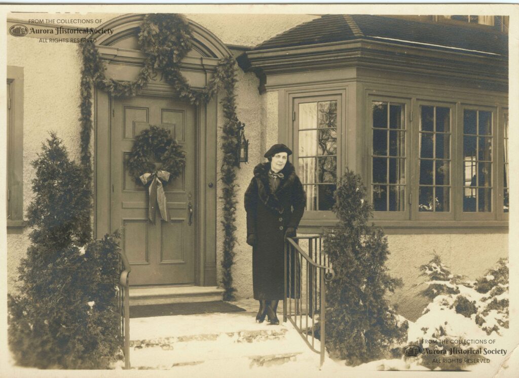 Luella Dude Kendall, wife of Myron Kendall, in front of their decorated home at 1211 Garfield, about 1940 (Aurora Historical Society photo)